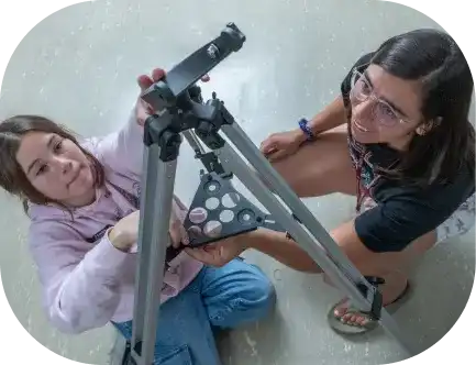 A DU student setting up a telescope for an astronomy project.